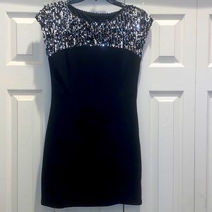 Black dress with silver sequins on the shoulders.